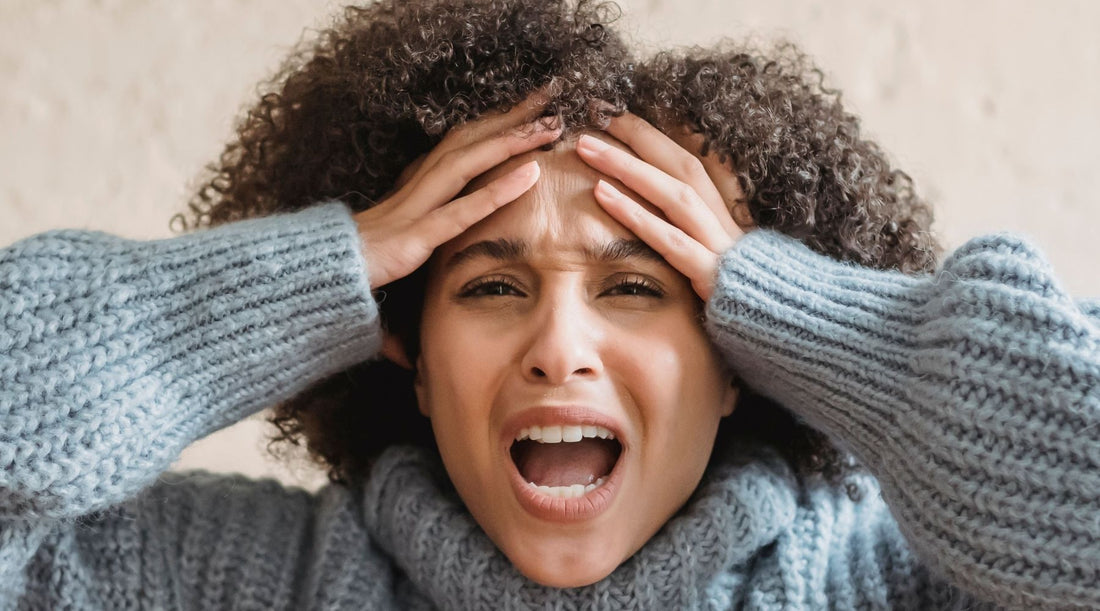 woman overwhelmed with hands to head