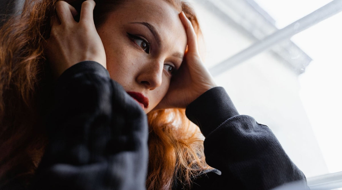 woman overwhelmed with hands to head